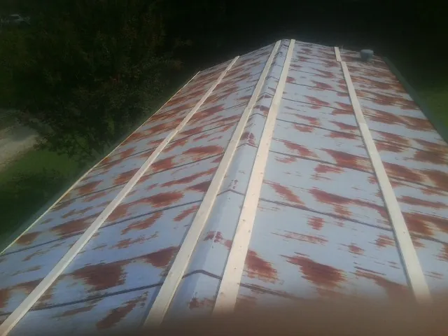 Rusted metal roof panels with new wood purlins before replacement — Storm Damage Roof Repair in Sanger by Roofing Brothers