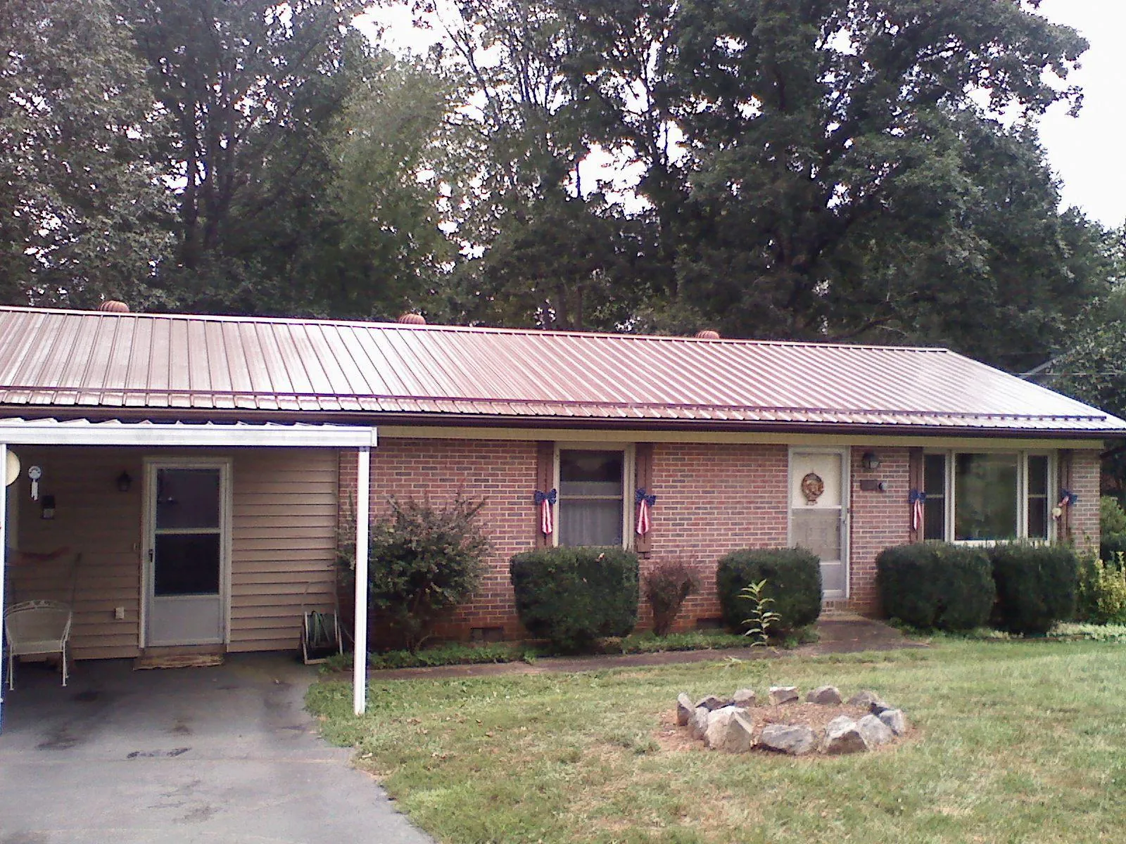 Bronze metal roof and carport on a brick ranch home — Roof Repair work by our crew in Sanger
