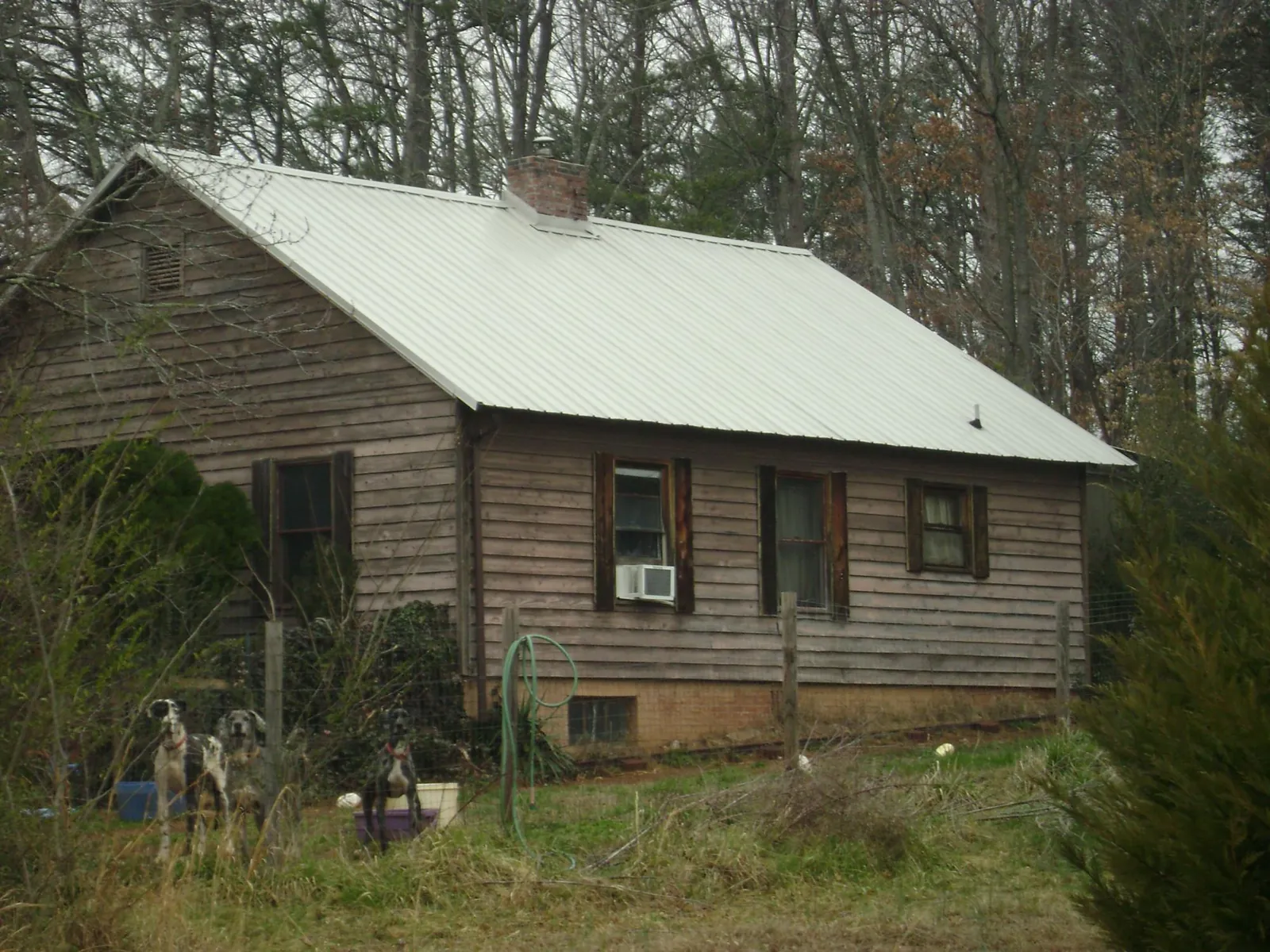 White metal roof on an old wood sided farmhouse, from a Metal Roof Installation job in Sanger